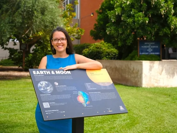 Doctoral student Zarah Brown with the plaque for "Earth and moon," which is part of solar system scale model installed on the UArizona campus